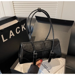 Detail of minimalist black PU shoulder bag with adjustable strap and metal buckle