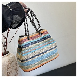 Close-up of colorful striped woven straw bag with silver chain and leather handle