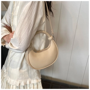 Beige Halbmond-Tasche mit kreisförmigem Griff und abnehmbarem Schultergurt am Model