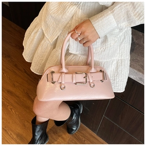 Gros plan d'un sac bowling rose avec boucle de ceinture décorative et anneau en métal