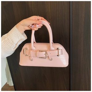 Détail du sac coquille rose clair en cuir brillant avec boucle argentée et sangles