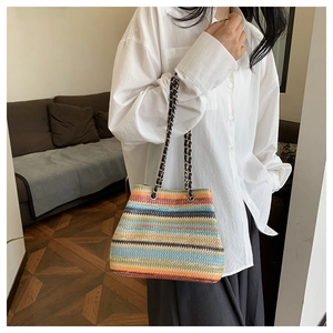Detail of colorful woven straw texture and stylish metal chain strap on bohemian tote bag