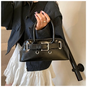 Gros plan d'un sac Boston noir avec finition brillante et boucles argentées de style