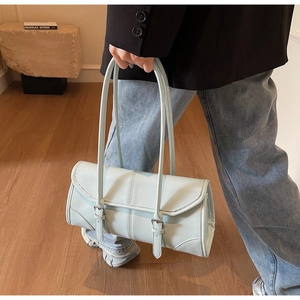 Detail of mint green leather handbag with vertical stitching and adjustable buckle straps