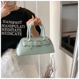 Gros plan du sac à main vert menthe avec boucle argentée et lanières décoratives en cuir