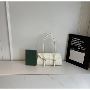 Close-up of a white minimalist shoulder bag with dual decorative metal buckle straps