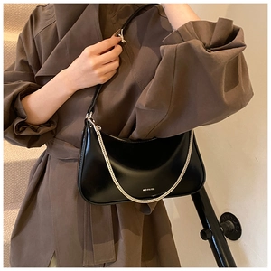 Close-up of black glossy leather dumpling bag featuring silver chain and NO FILTER text