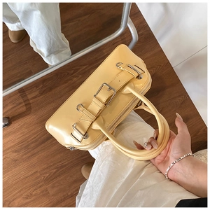 Détail du sac à main crème avec boucles argentées et texture en cuir premium