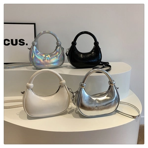 Detail view of four glossy patent leather crescent handbags in multiple stylish colors
