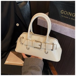 Détail d'un sac coquillage beige crème avec une finition brillante et une boucle
