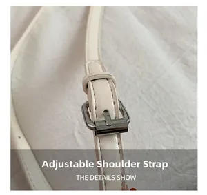 Detail shot of the adjustable white faux leather shoulder strap with silver buckle