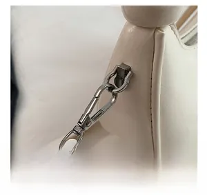 Detailed close-up of the silver metal buckle and cracked leather texture on a white bag
