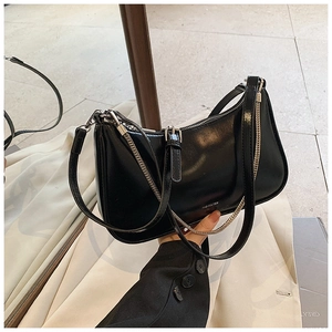 Close-up of black leather underarm bag featuring silver chain and NO FILTER text detail