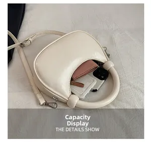 Interior capacity show of cream half-moon bag with smartphone and pink wallet inside