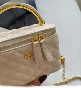 Close-up of beige quilted bucket bag with gold flower detail and chain strap