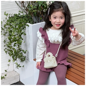 Gros plan d'un sac à main tissé en perles pour fille avec des détails de perles blanches