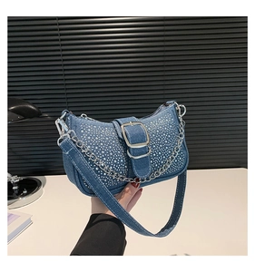 Gros plan du sac baguette en jean bleu avec strass dégradés et chaîne métallique argentée