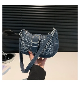 Détail du sac baguette en jean bleu avec strass argentés et bandoulière chaîne