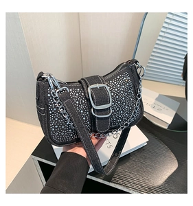 Détail du sac bandoulière en denim noir avec strass argentés et boucle métallique