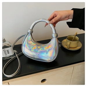 Close-up of iridescent silver crescent handbag with wrinkled texture and ring handle