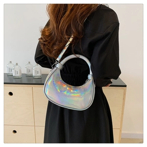 Detail of silver holographic crescent handbag featuring iridescent texture and metal ring handle