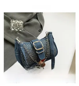 Detalle del bolso baguette de mezclilla azul con pedrería plateada y hebilla metal