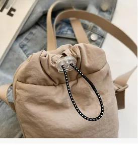 Detail of drawstring closure and durable fabric on stylish khaki mini shoulder bag