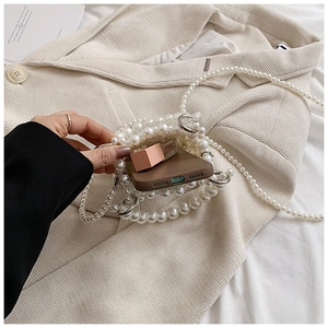 Detail of handmade pearl woven bag showing silver rings and daily essentials storage