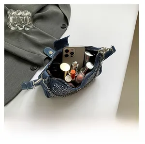 Vue intérieure du sac baguette en jean montrant l'espace pour téléphone et rouges