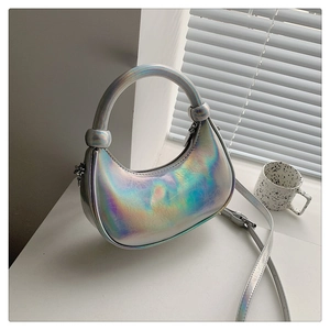 Detail of silver iridescent crescent bag with textured finish and knotted handle
