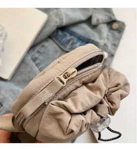 Close-up of smooth zipper closure and drawstring detail on khaki nylon bag