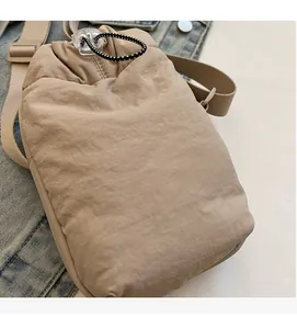 Close-up of beige nylon phone bag showing soft fabric texture and drawstring buckle