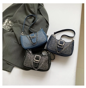 Trois sacs baguette en denim et strass en bleu clair, bleu foncé et noir sur fond blanc