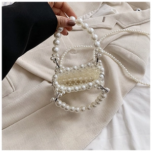 Detail of handmade pearl mini handbag with crossbody chain and elegant woven texture