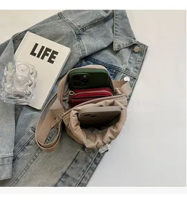 Internal view of a brown canvas crossbody bag showing space for phones and a wallet