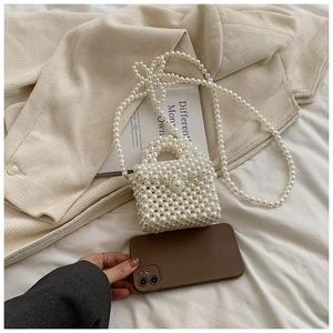 Détail de mini sac à main en perles tissées montrant la chaîne et la petite taille