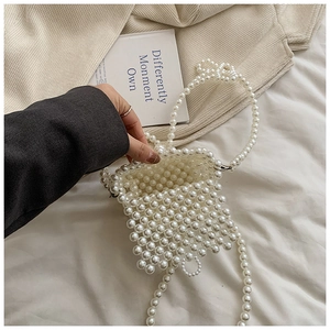 Détail d'un sac bandoulière en perles blanches fait main avec une bandoulière assortie