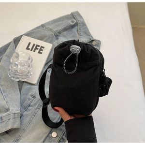 Detail of black nylon drawstring bag with adjustable strap and cord stopper close-up