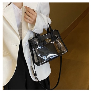 Detailed side view of clear PVC Kelly bag with black leather trim and gold twist lock