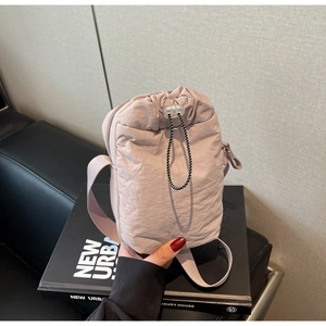 Close-up of light purple canvas drawstring bag with pleated nylon texture and strap