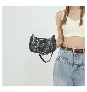 Détail du sac baguette en jean bleu avec strass brillants et chaîne en métal argenté