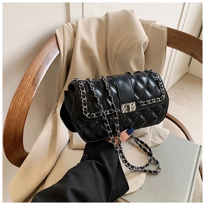 Detail of quilted leather texture and silver chain strap on a black crossbody bag