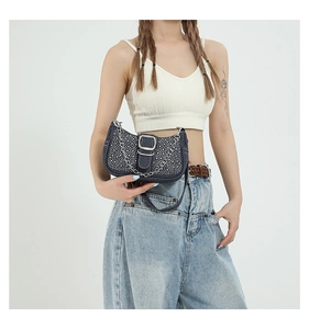 Sac baguette en denim avec strass et chaîne argentée porté par un mannequin