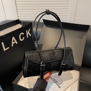 Minimalist black leather baguette handbag with silver buckle straps and slim shoulder straps