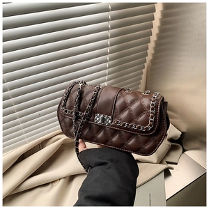 Detail of dark brown quilted crossbody bag with silver hardware and leather chain strap