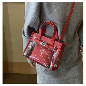 Detailed view of red transparent PVC handbag with inner pouch and metallic buckle lock