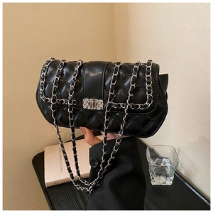 Close-up of quilted black crossbody bag featuring metal chain strap and luxury lock detail
