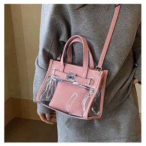 On-body shot of a pink clear PVC crossbody bag with leather trim and metal clasp details