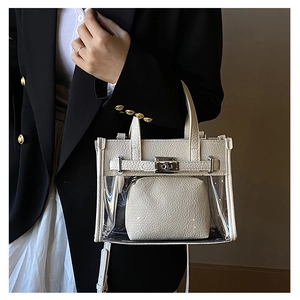 Detail of white lychee leather and clear PVC handbag with silver metal turn-lock closure