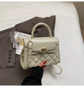 Dettaglio dell'elegante borsa color crema con cuciture trapuntate e chiusura dorata